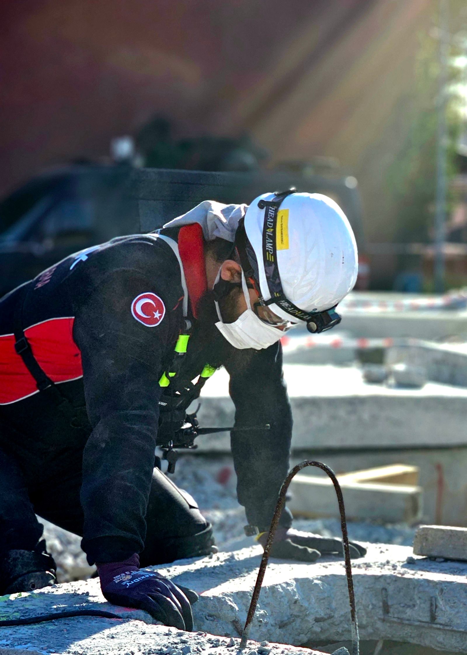 A construction worker in a helmet and high-visibility clothing outdoors.